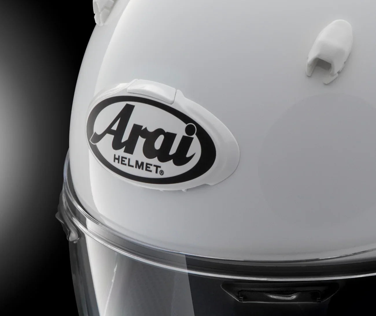 White Arai motorcycle helmet with clear visor and brand logo, premium protective gear for riders